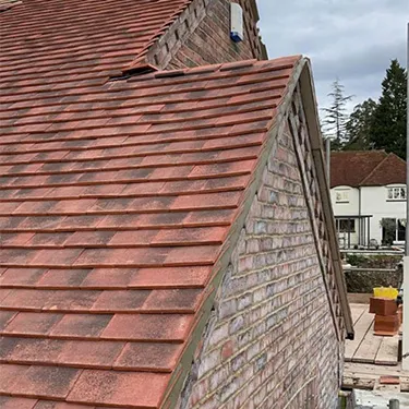 a cat sitting on top of a red roof