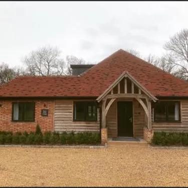 a brick and wood house with a large driveway